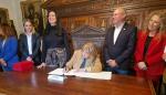 La consejera de Presidencia, Tomasa Hernández, firma en el Libro de Honor del Ayuntamiento de Huesca ante la sonrida de su alcaldesa, Lorena Orduna.